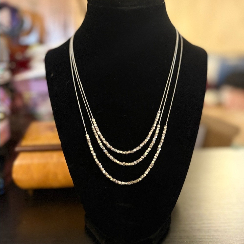 Beautiful three strand silver toned necklace.